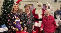 Santa with Fenland District Council community support officer Hayley Mears (left), Cllr Sam Clark, Golden Age team leader, and Marjorie (Madge) Cotterell (right), widow of the late Cllr Mac Cotterell who founded Golden Age fairs 22 years ago!